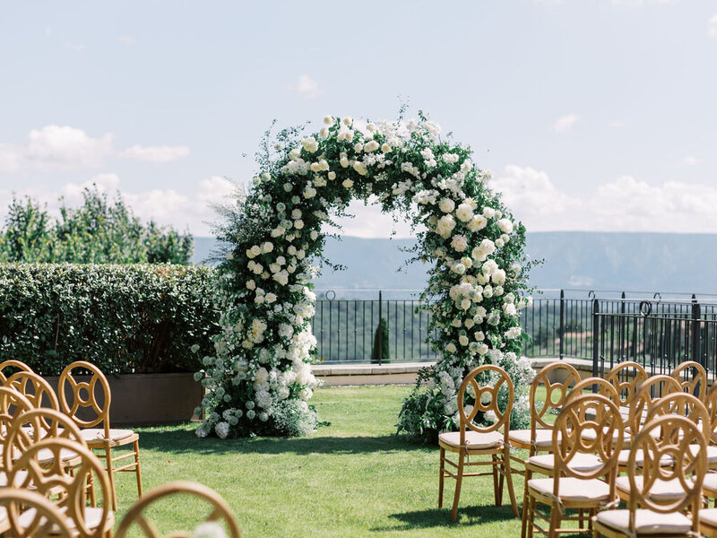 white floral arch ceremony  in the garden