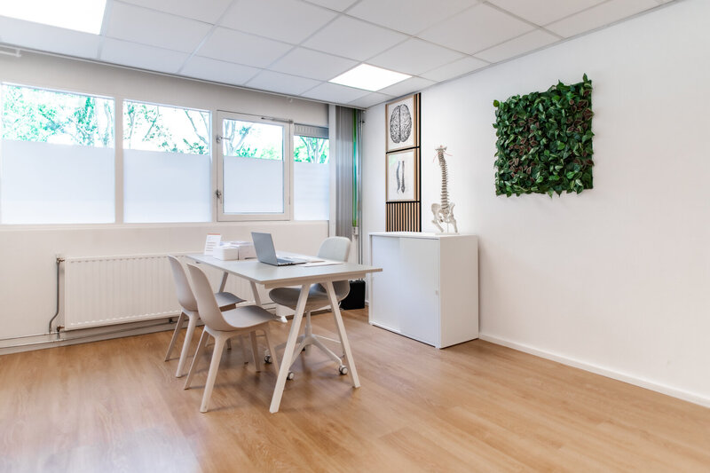 Lege behandelruimte met tafel en stoelen
