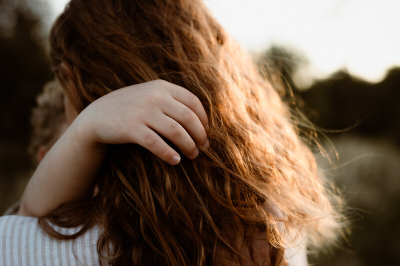Detail shot of a son giving his mother a hug as they have their photography done by Courtney Blury of Blury Photography