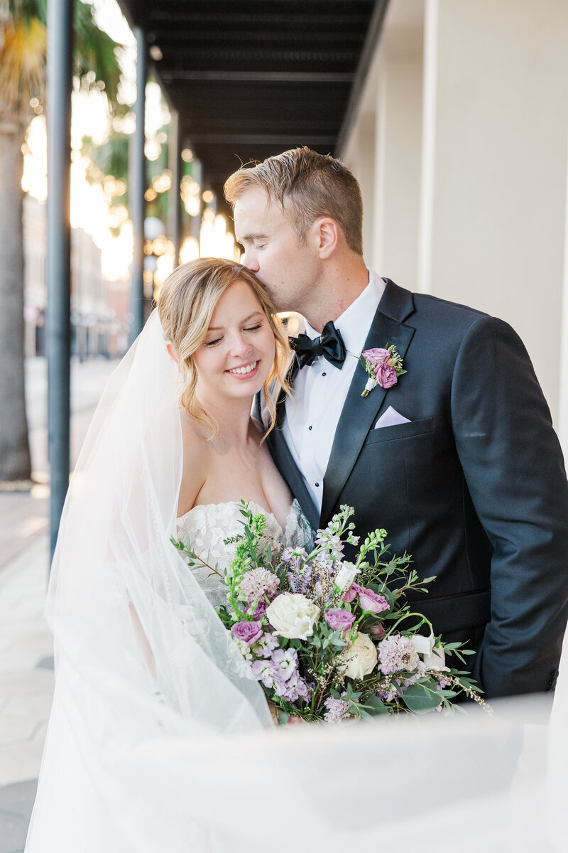 groom kissing bride on the head