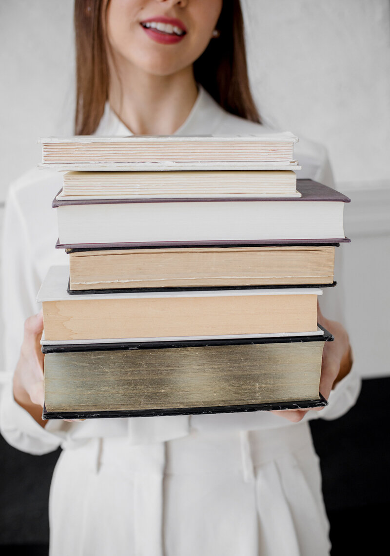 Woman holding stack of books