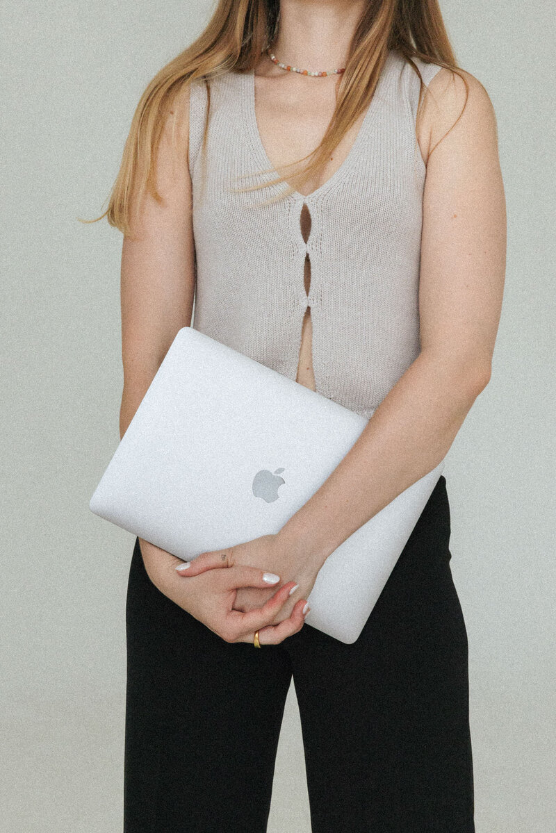 Anna hält einen Laptop in der Hand, bereit zum Arbeiten.