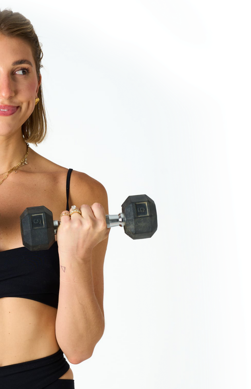Women holding weights in her hands doing a bicep curl 