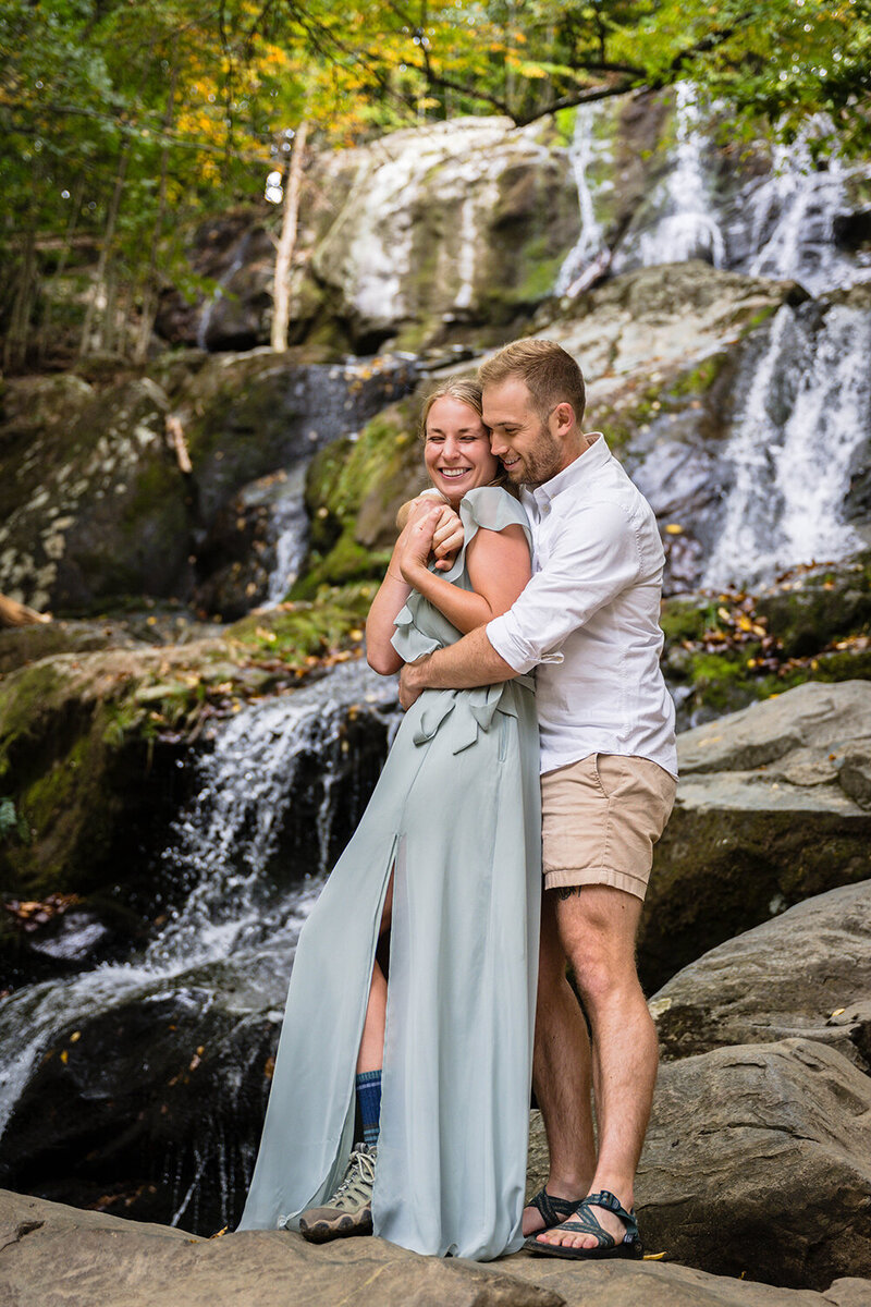 A couple stands in front of a waterfall in Shenandoah National Park on their elopement day.
