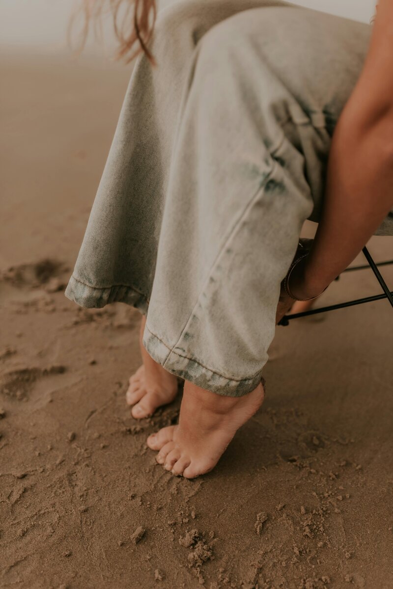 Photo of stool and founder jaclyn on beach posing with laptop and working on a social media project