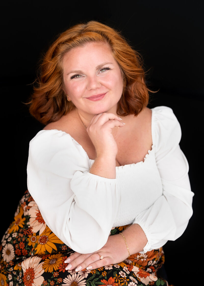 Hannah Smith smiling at camera wearing white top and floral skirt.