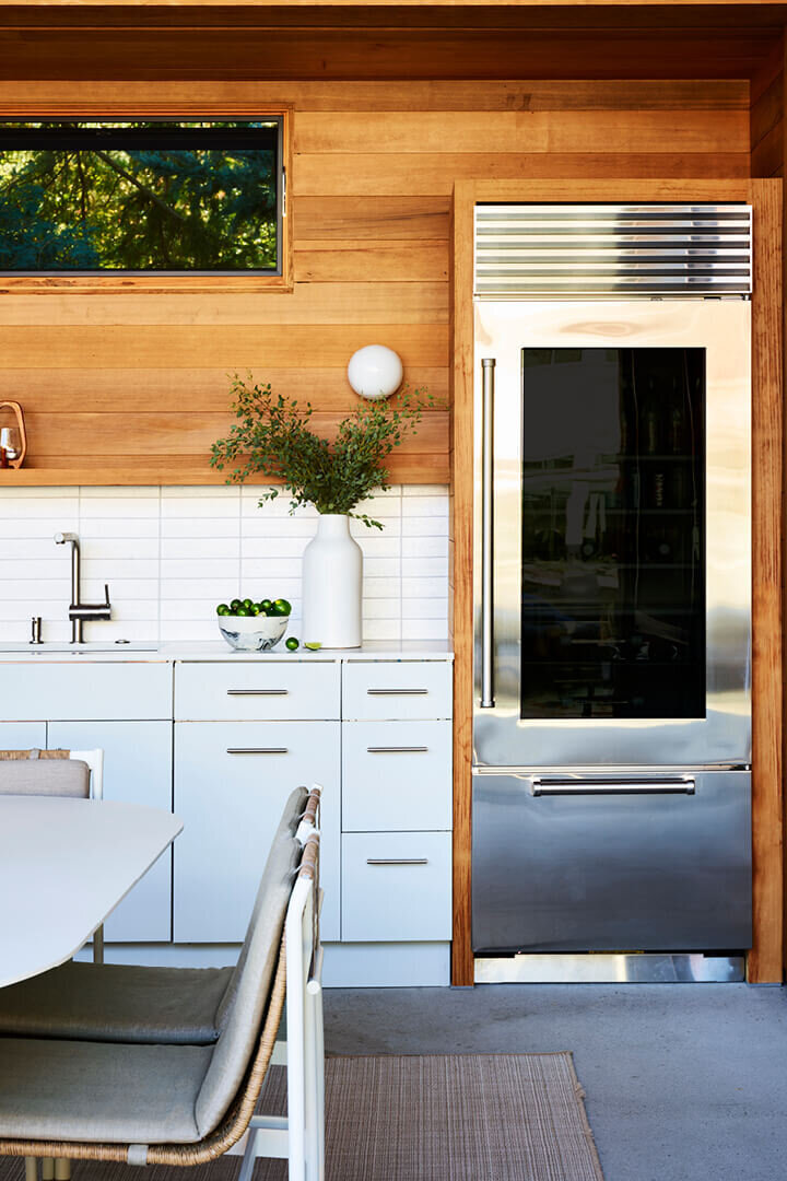 Boston kitchen designer creates an outdoor space at a Hingham pool house with stylish design elements for cooking, dining, and entertaining.