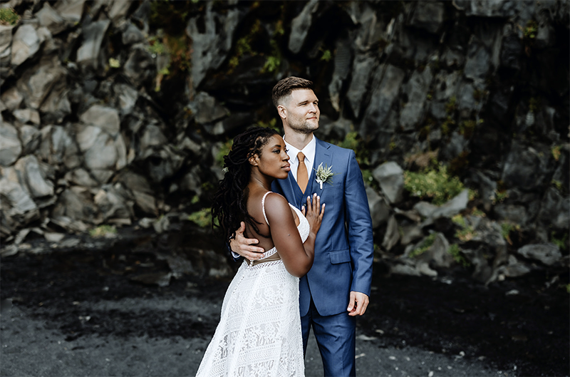 bride and groom are posing in a cave in Iceland on their wedding day