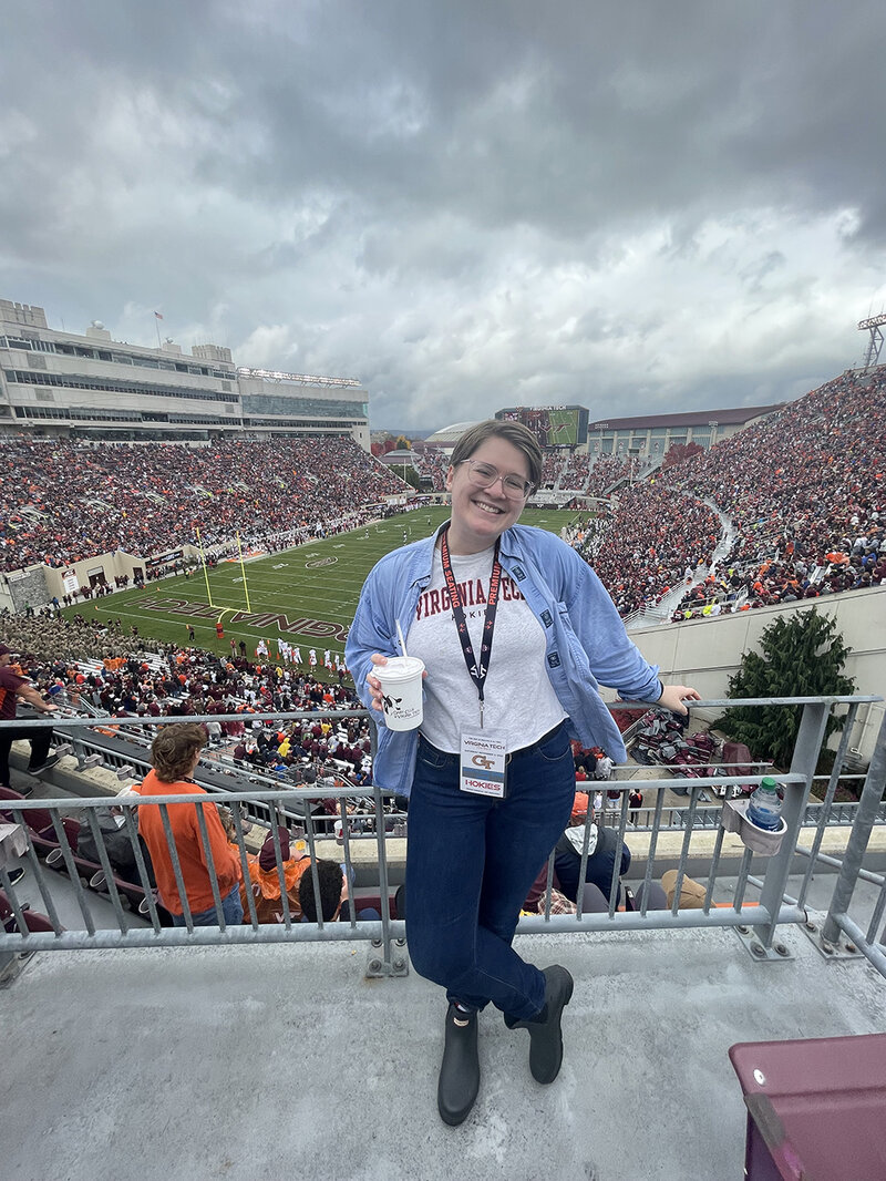 A Virginia wedding photographer stands inside of Lane Stadium during a football game.