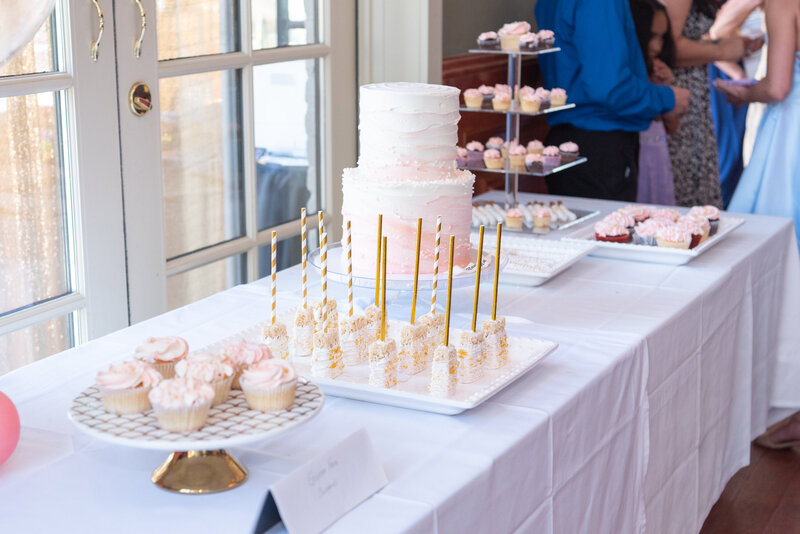 A sweet table at a birthday party with cake, cake pops, cupcakes and more.