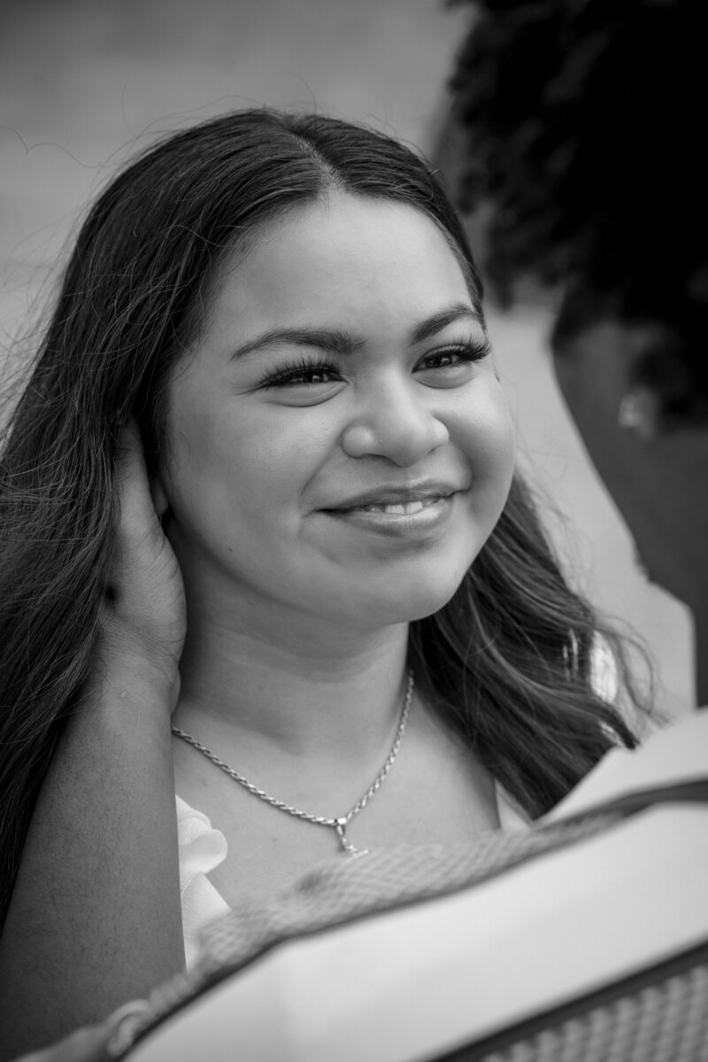 Candid engagement moment of woman smiling at her fiancé in Charlotte, NC rooftop setting by DeLong Photography.