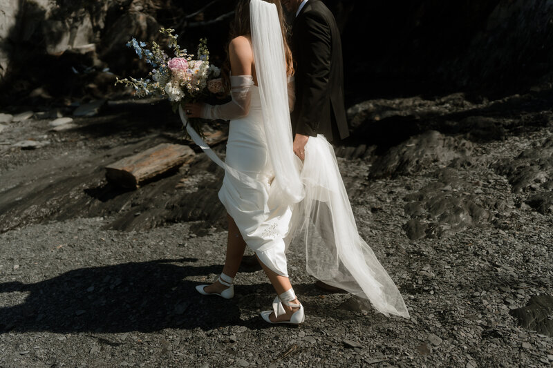 bride and groom walking on the beach