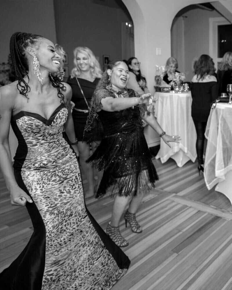 Women dancing and celebrating at a lively event gathering.