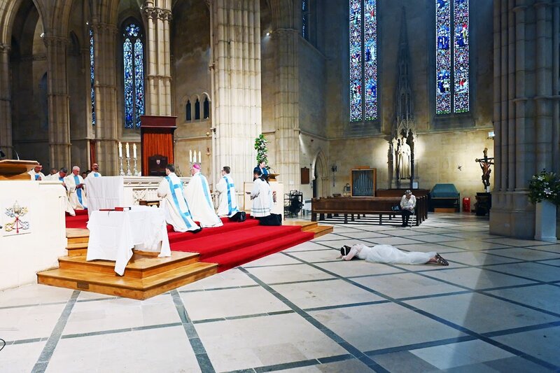 a young woman lying prostrate in a Catholic church