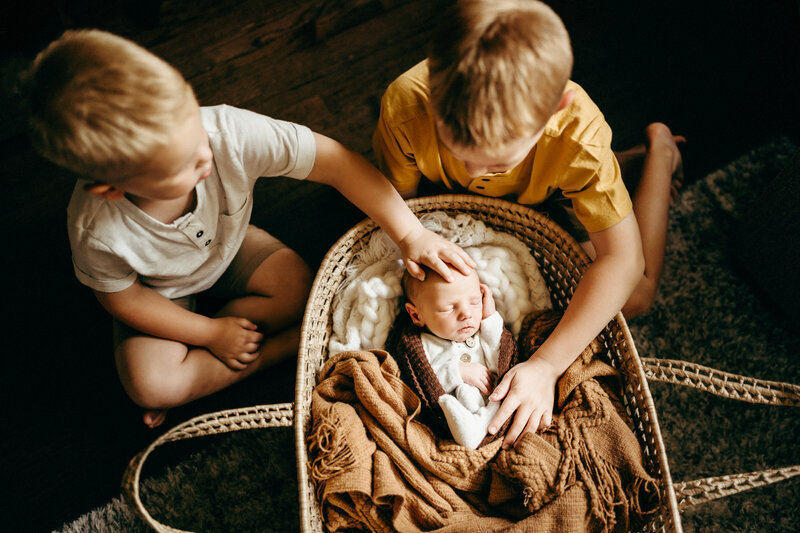 3 little boys- older boys touching baby in bassinet