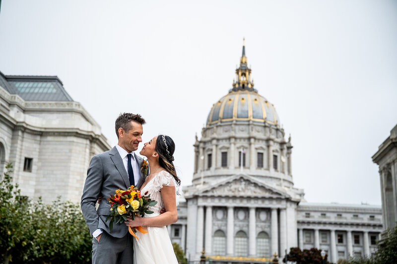 San Francisco wedding photographer captures couple portrait with iconic City Hall dome and neoclassical architecture