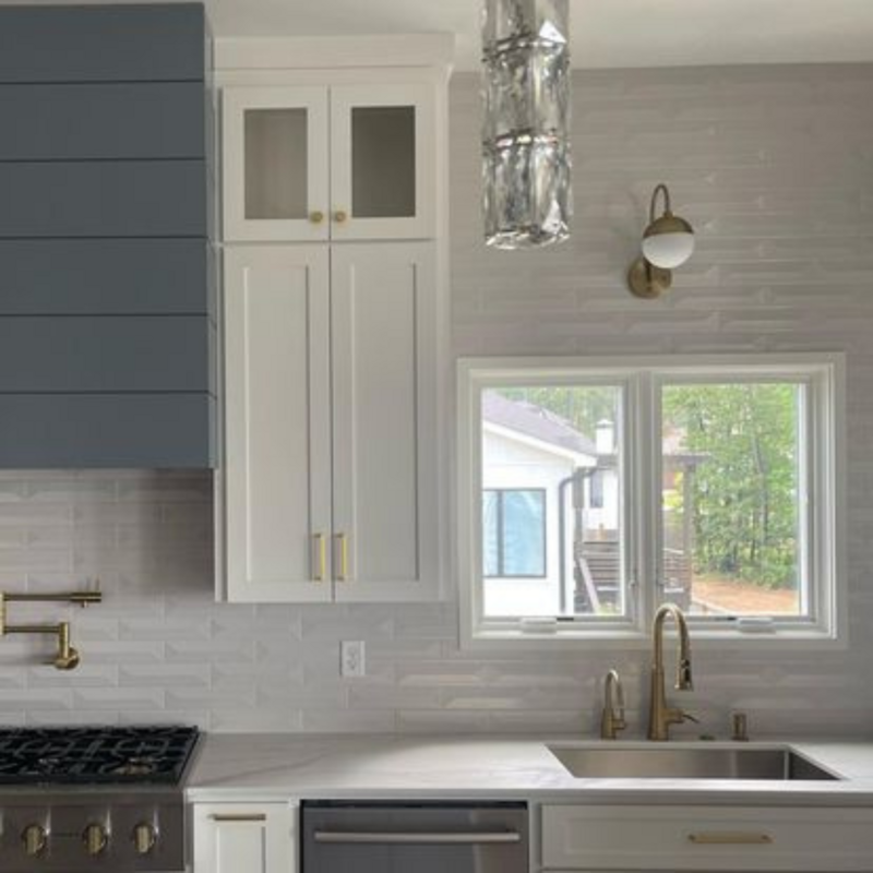 Kitchen with white cupboards and new textured, white backsplash tile.