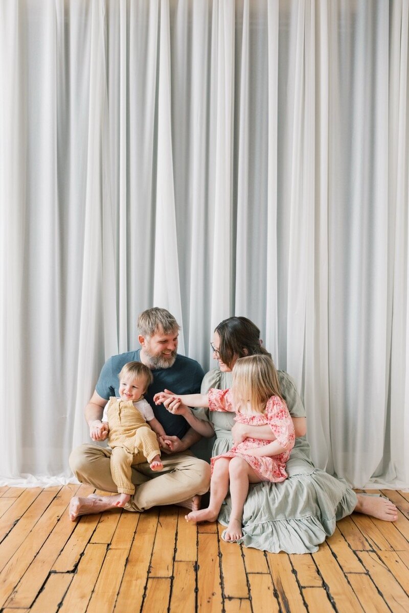 Margit and her family sitting together on the floor