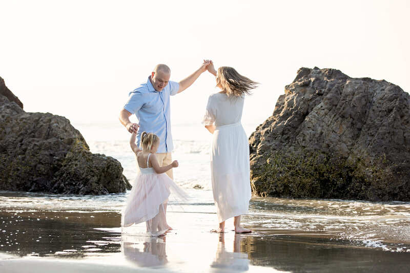 Family dancing on the sand at Avila Beach, CA during a family photo session with One Good Shot Photography 