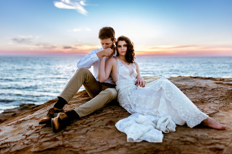 A dreamy Pacific Northwest elopement with a couple sharing a sunset kiss on a rugged coastal cliff.