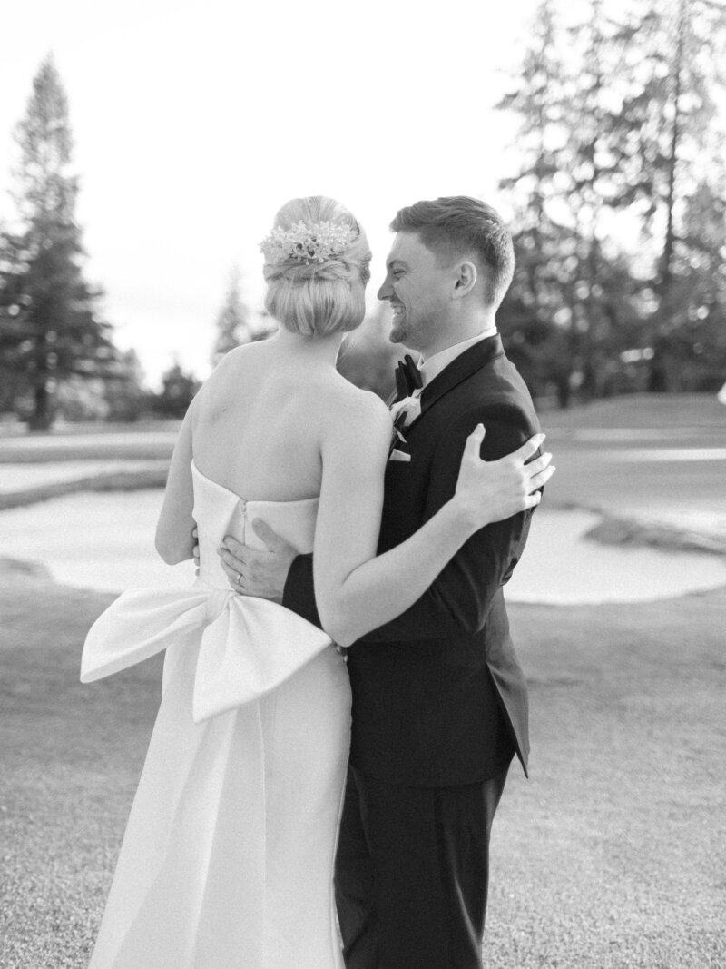 modern bride and groom at golf course in black and white with bride wearing a vintage heirloom wax flower crown restyled into a modern bridal hair comb