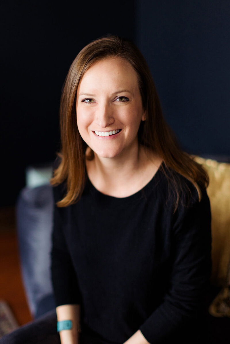 A woman sitting on a couch with a big smile