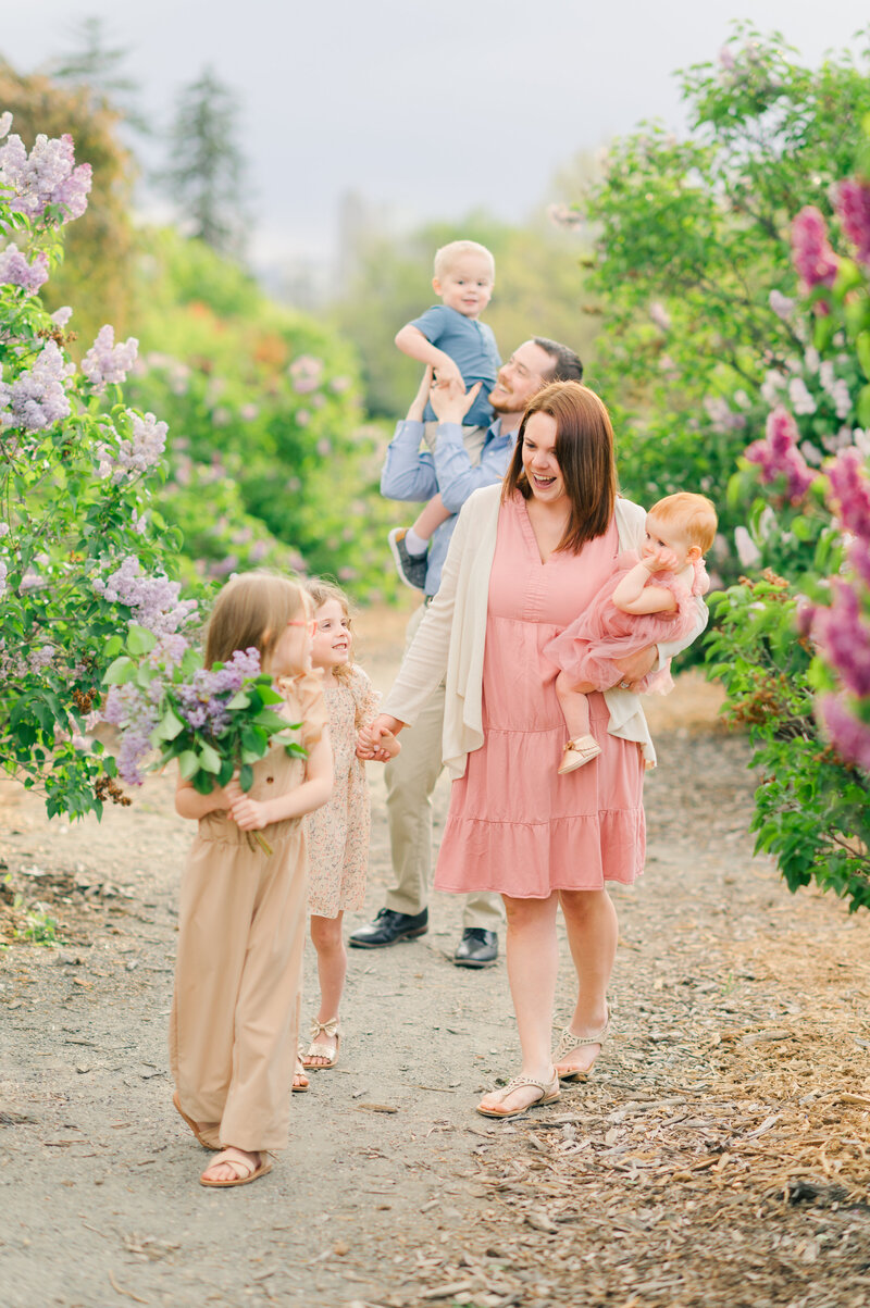 colorado wedding photographers sitting walking with her children and husband in a garden of purple flower bushes along a gravel path