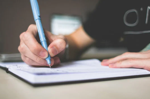 Person holding blue ballpoint; picjumbo.com