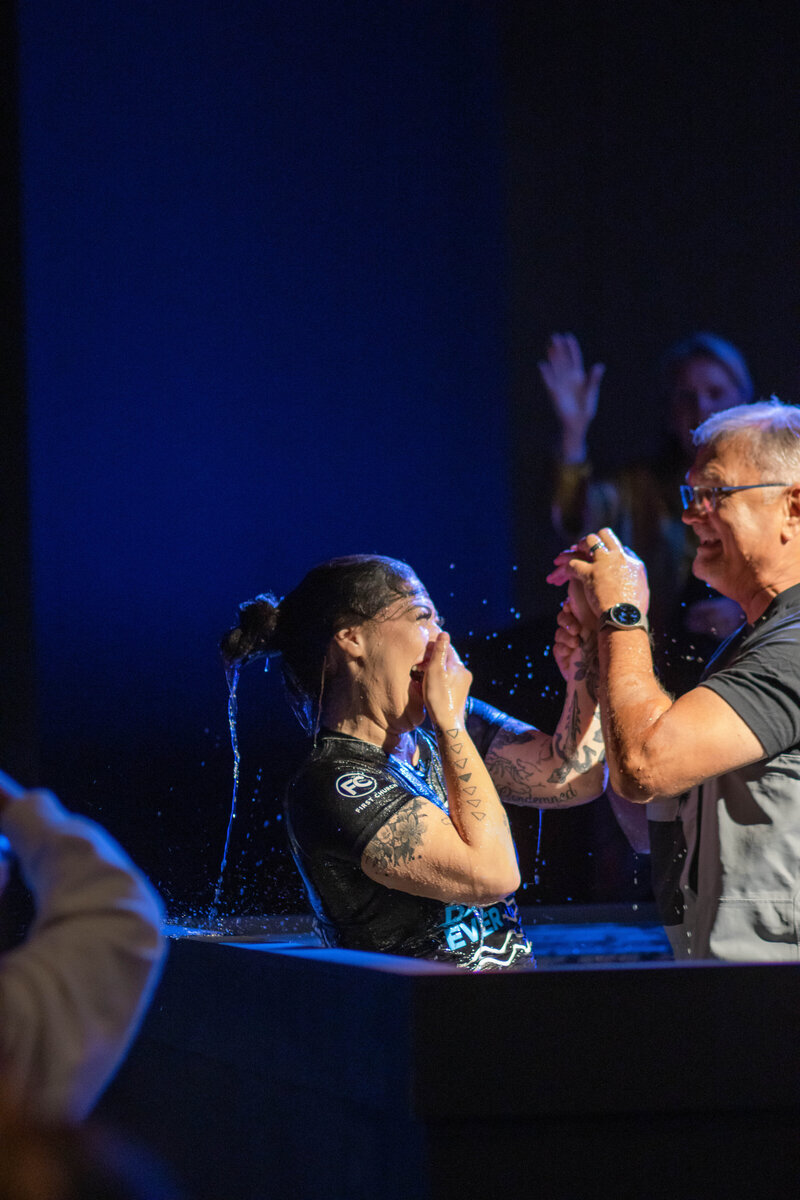 Young latina woman being water baptized at a non-denominational church in Fayetteville, NC. 