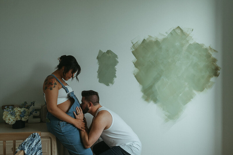 man kissing woman's stomach during maternity photoshoot by Elsie Goodman Photography