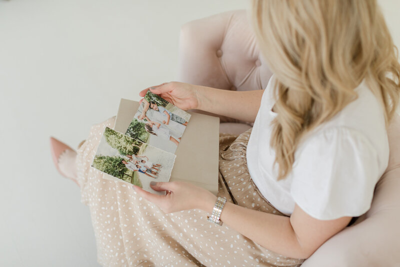 Close up of woman holding phots and an  album.