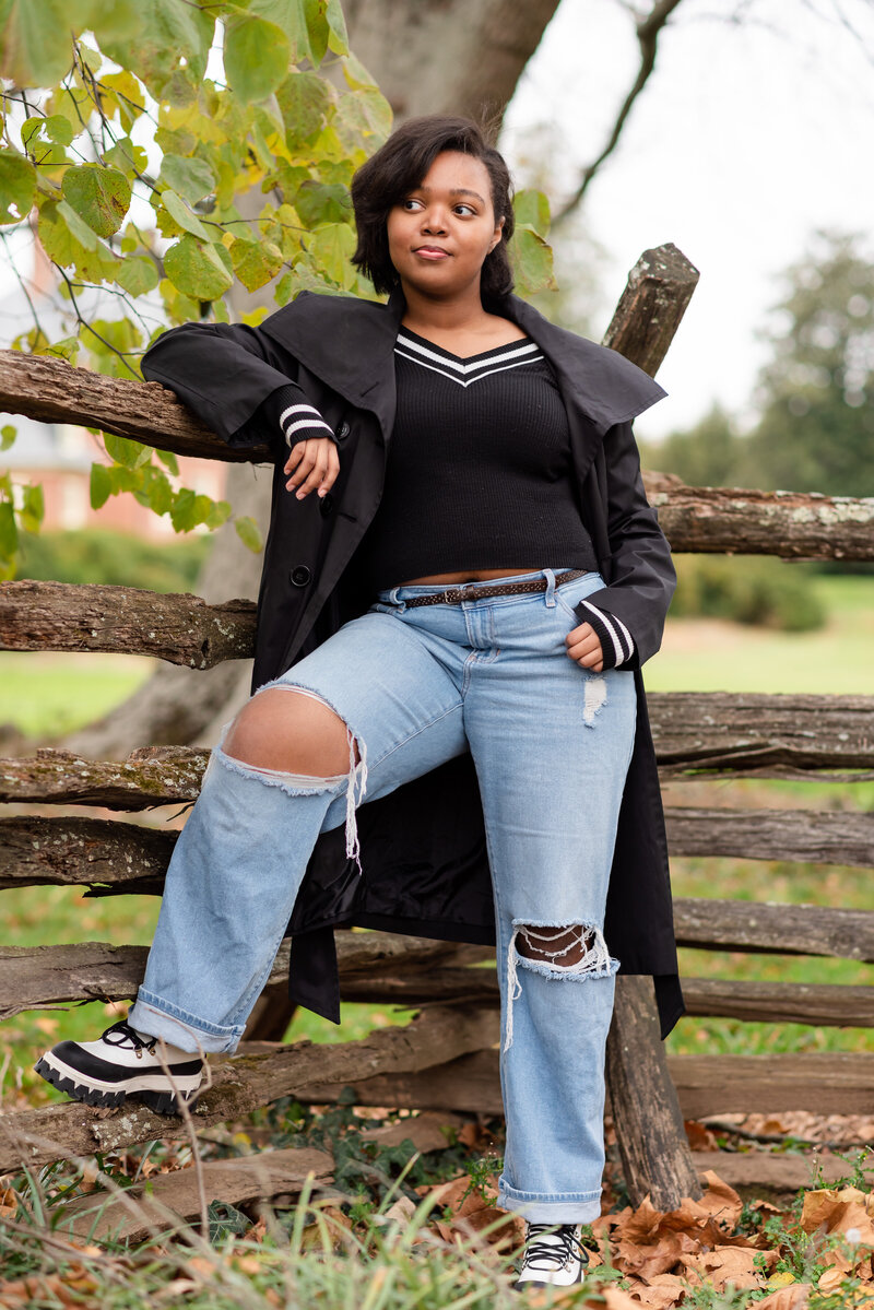 Photo of senior girl in photo leaning on a fence on a mansion in Maryland