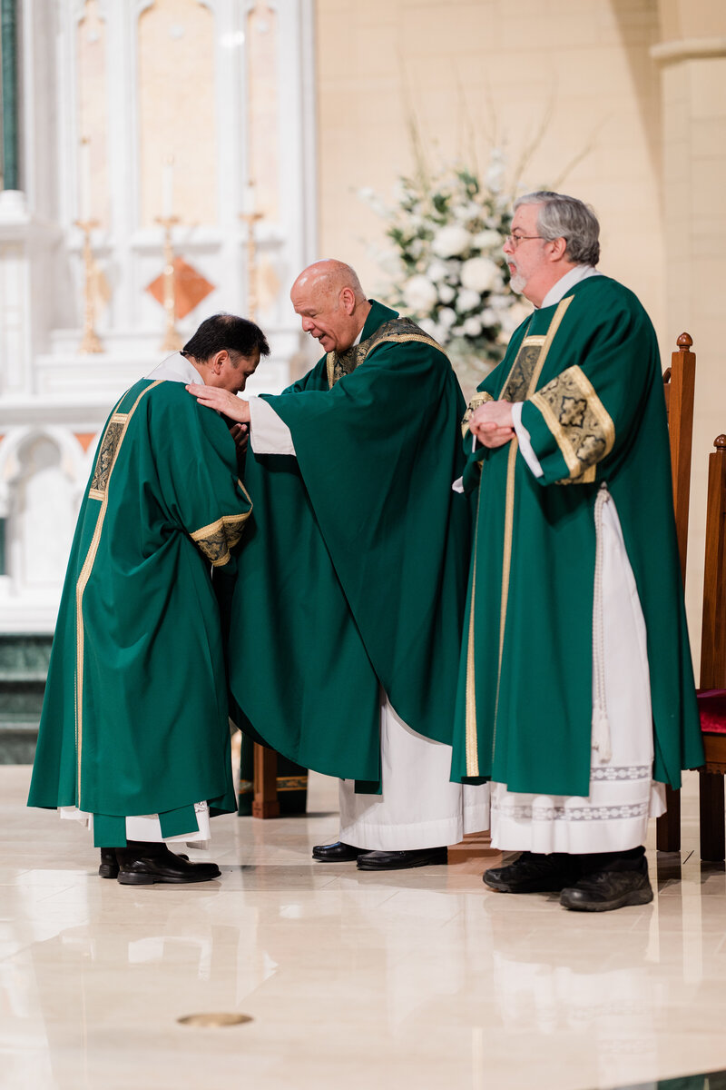 Three men gathered in a church for blessing.