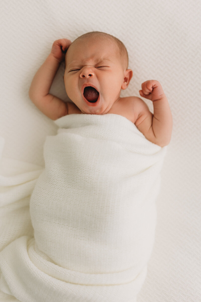 Newborn photo of a baby in studio yawning in Kelowna BC