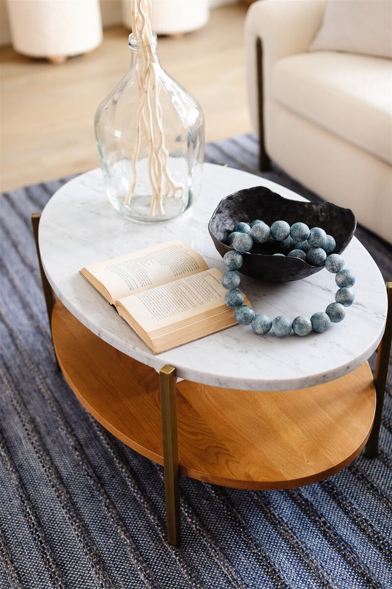 Blue beaded garland and book accent on marble living room table