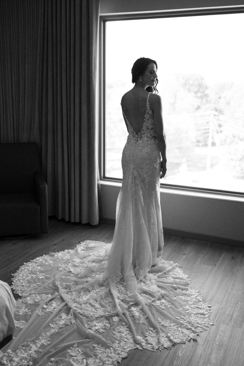 A stunning bride stands in front of a window, showcasing the elegant details of her wedding dress. Girasole & Co. Weddings—Columbus, Ohio’s premier wedding planner—helps engaged couples design and execute their dream wedding with expert planning and seamless coordination. Let us bring your vision to life with stress-free, personalized wedding planning.