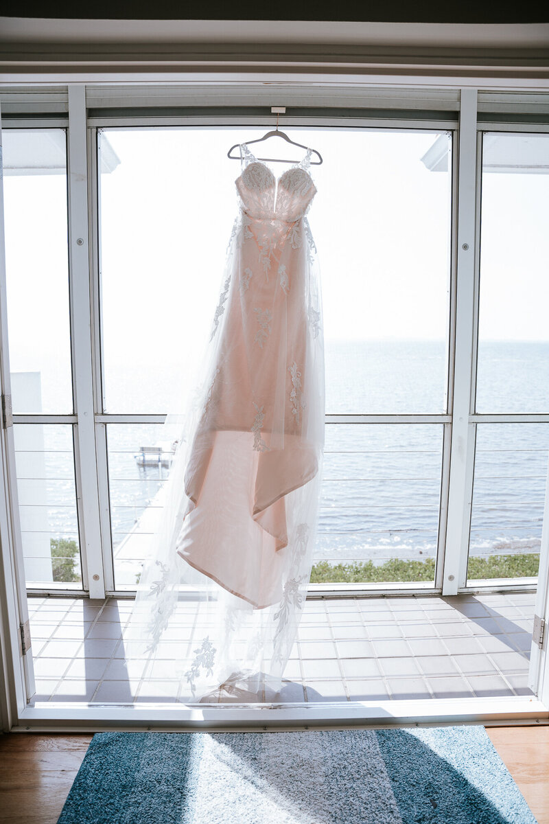 Wedding Dress hanging in the window photographed by Sarasota Wedding Photographer