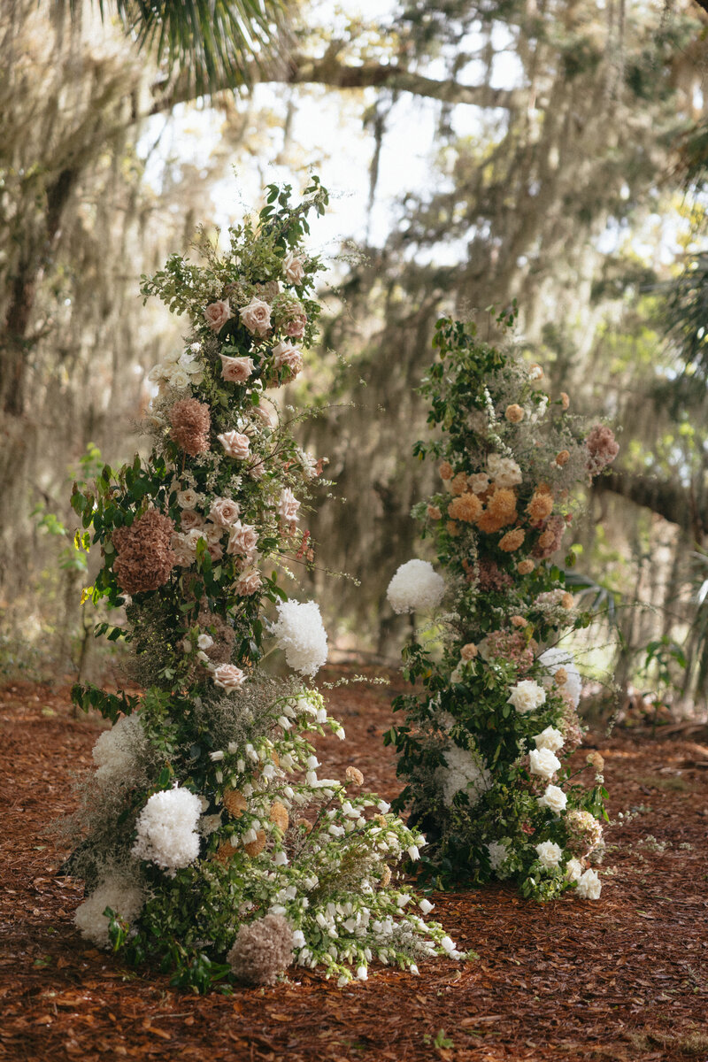 Lush, whimsical floral towers ,with muted tones, ferns, and textural blooms, styled by The Eventful Gals for a high-end Florida wedding.
