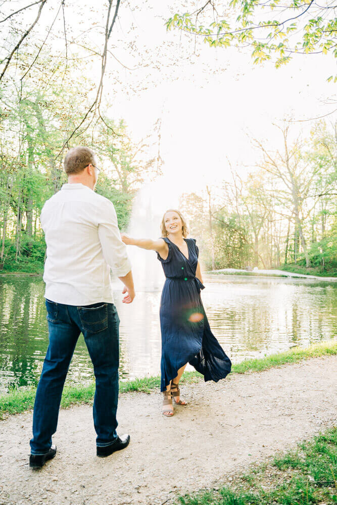 A couple dances together during their engagement photography session on a lake outdoor wedding venue in Michigan.