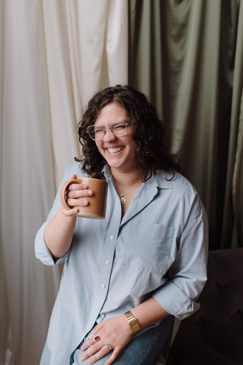 Loren Marshall LPC drinking coffee and laughing in a warm theraputic manner 