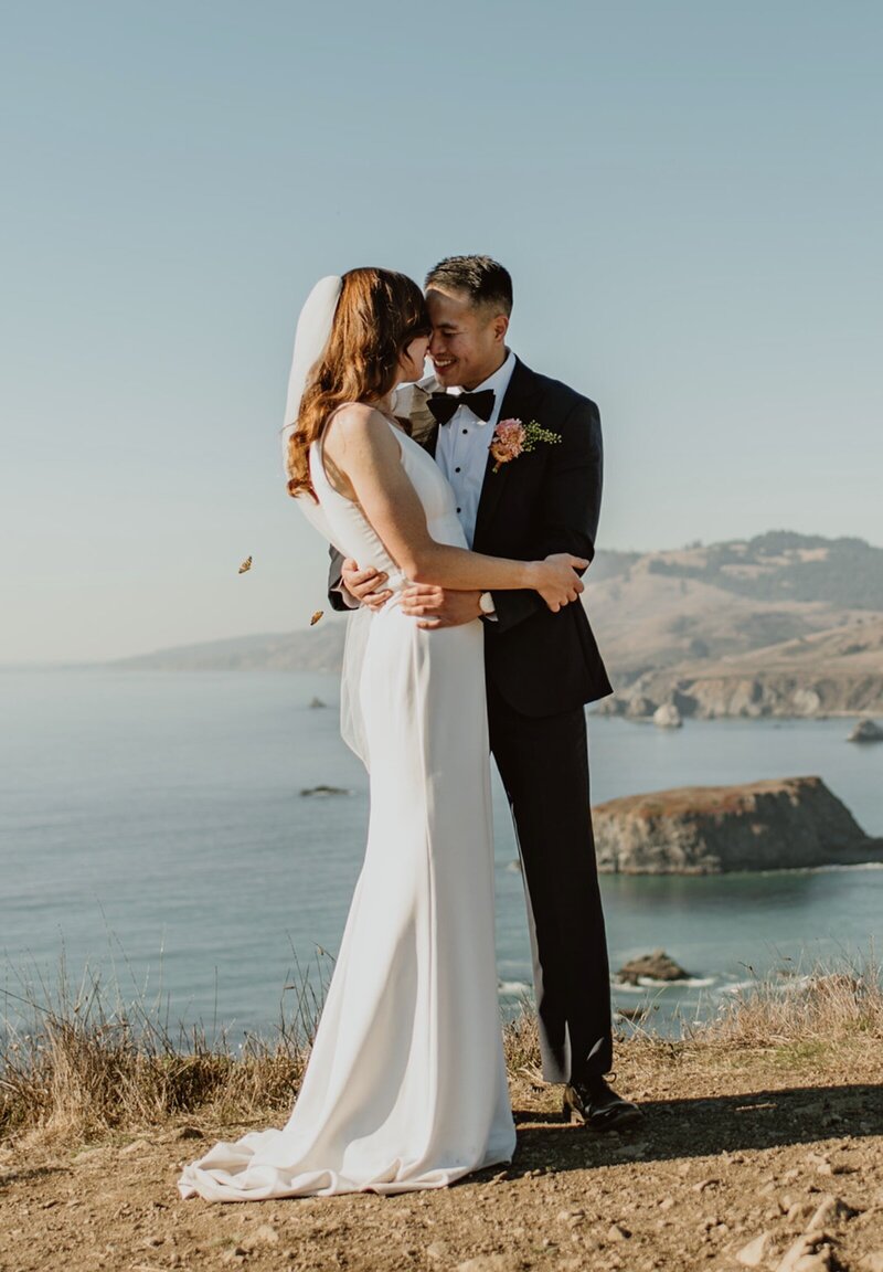 Couple embracing and sharing a quiet moment on the Sonoma County coast during their all-day Northern California elopement
