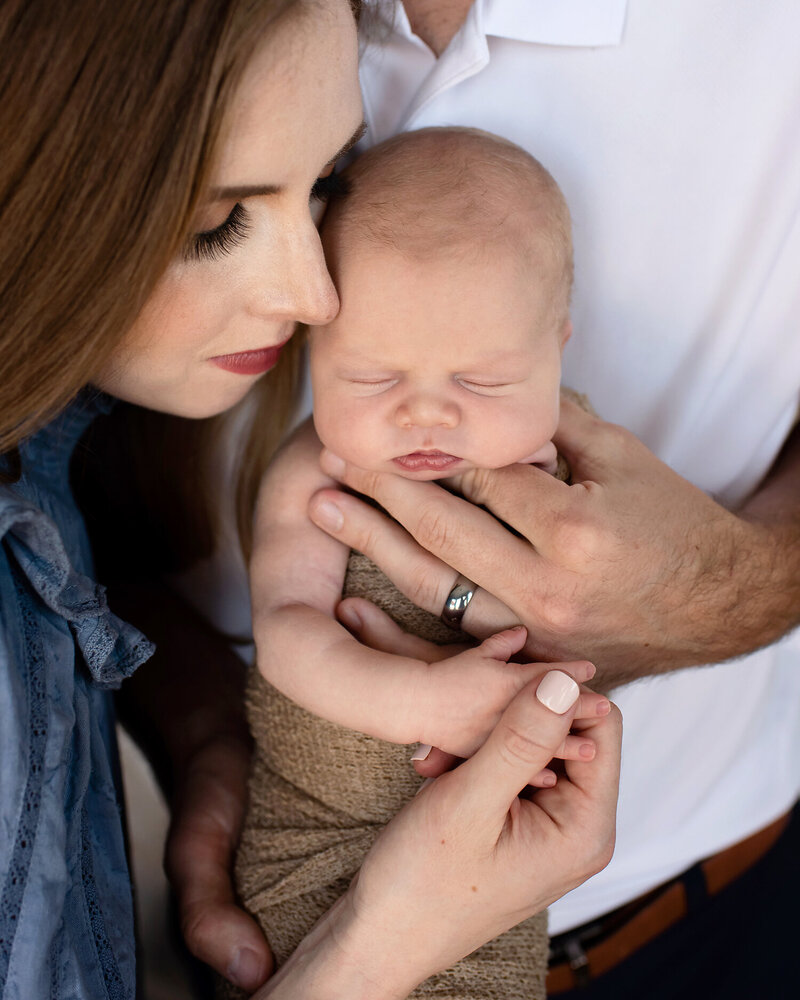 Big brother holding his newborn brother during an in-home newborn session in Allen, TX