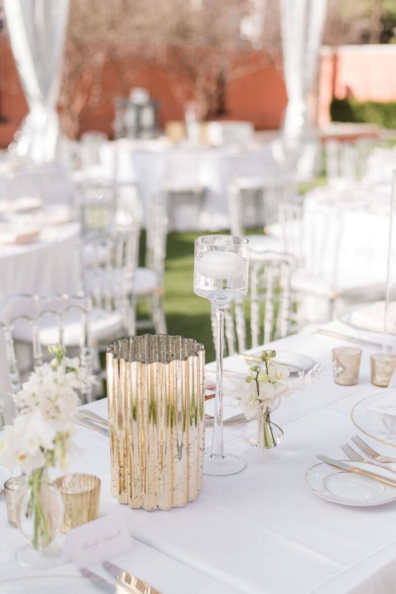 Wedding table setting with gold, glass, and white accents
