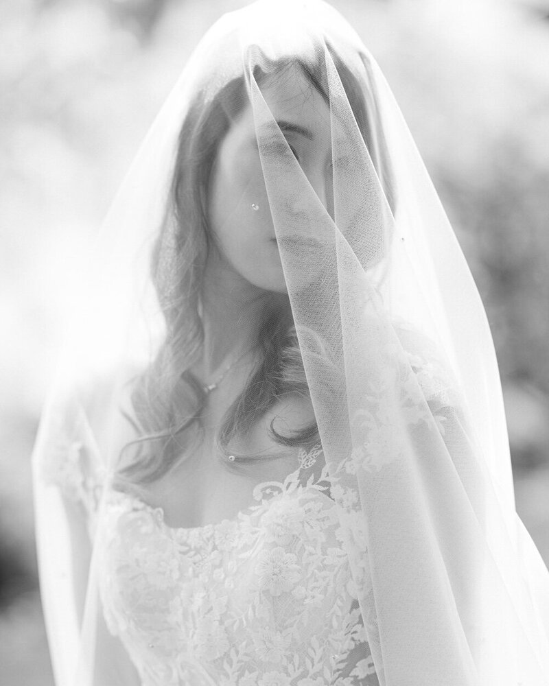 This intimate close-up photograph captures the bride gazing into the camera on her wedding day in Calgary. Her elegance and beauty are highlighted, creating a timeless and emotional moment that reflects the joy of her special day.