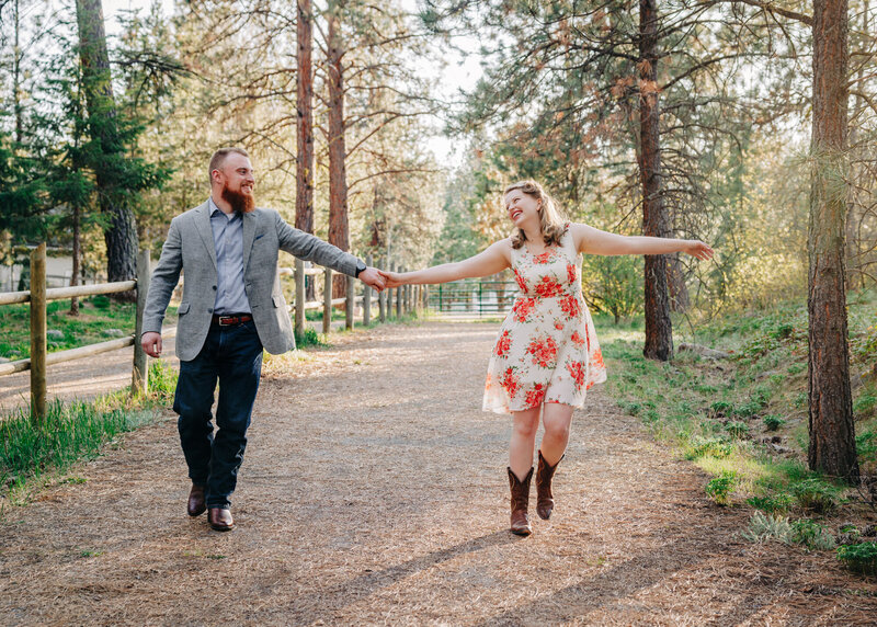 Engagement photo Missoula couple holding hands walking in forest at Lincolnwood Trailhead