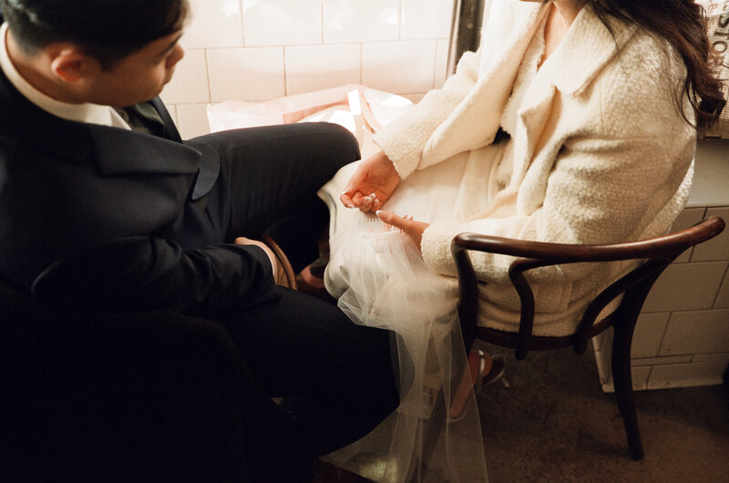 Couple sitting next to each other in at a restaurant in boston after their elopement  — captured by a city hall wedding photographer.