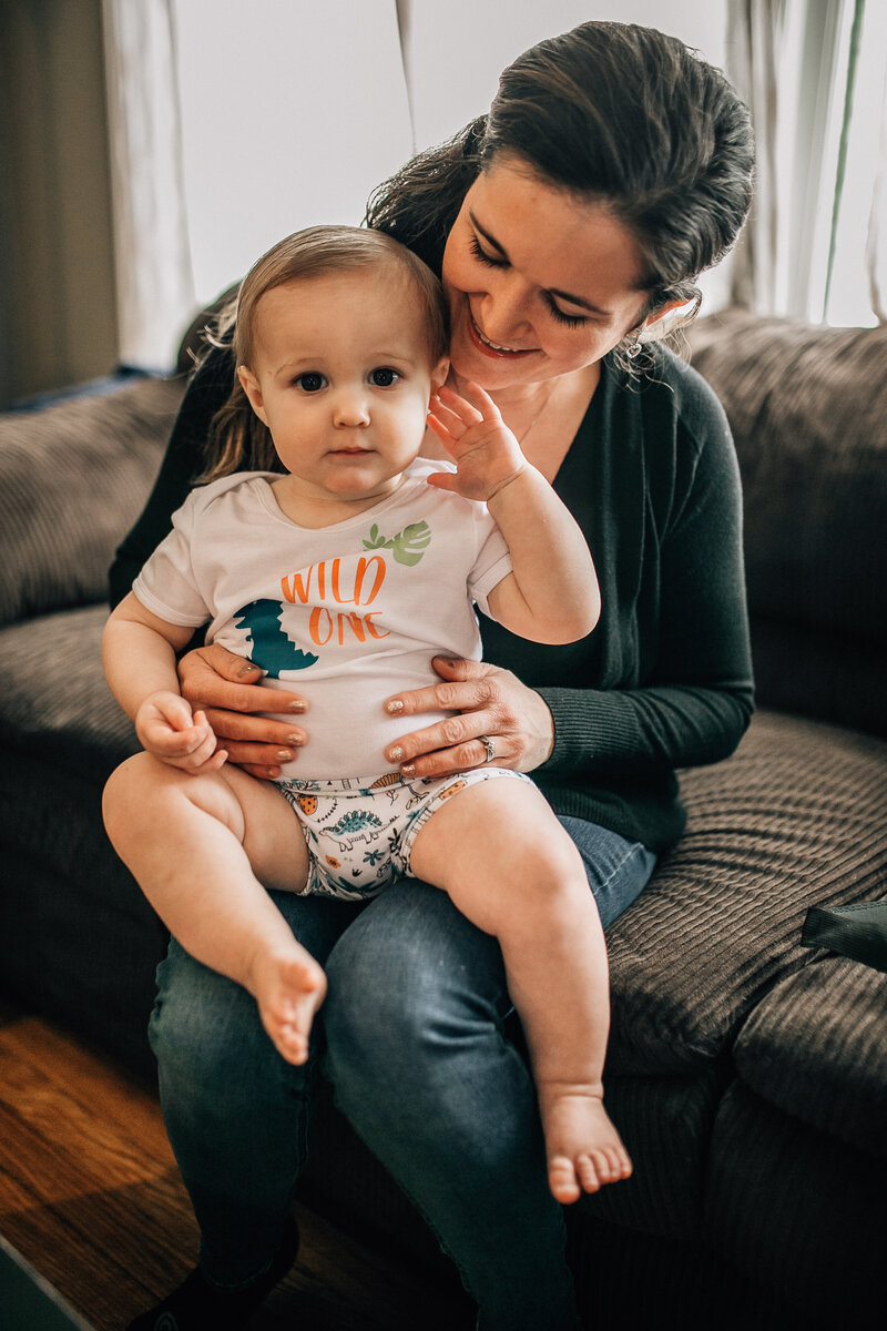 Milestone photo with young baby sitting on mom's lap
