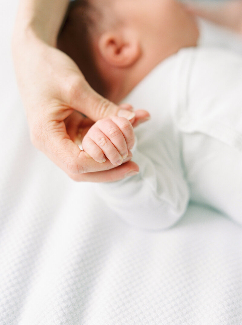 Close up of mom holding baby hand - Fika Newborn