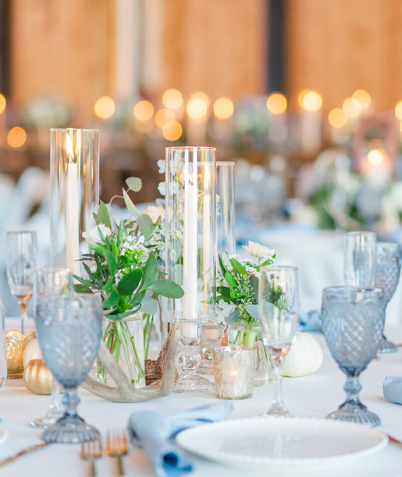 A candlelit wedding reception with blue and white table settings.