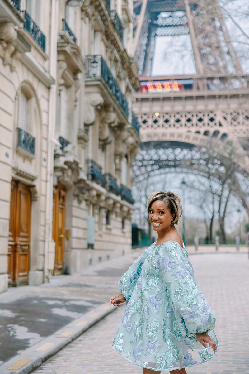 Woman wearing dress smiling at camera during Paris Solo Photoshoot by Eiffel Tower